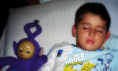 Niño durmiendo con muñeco de Teletubbies